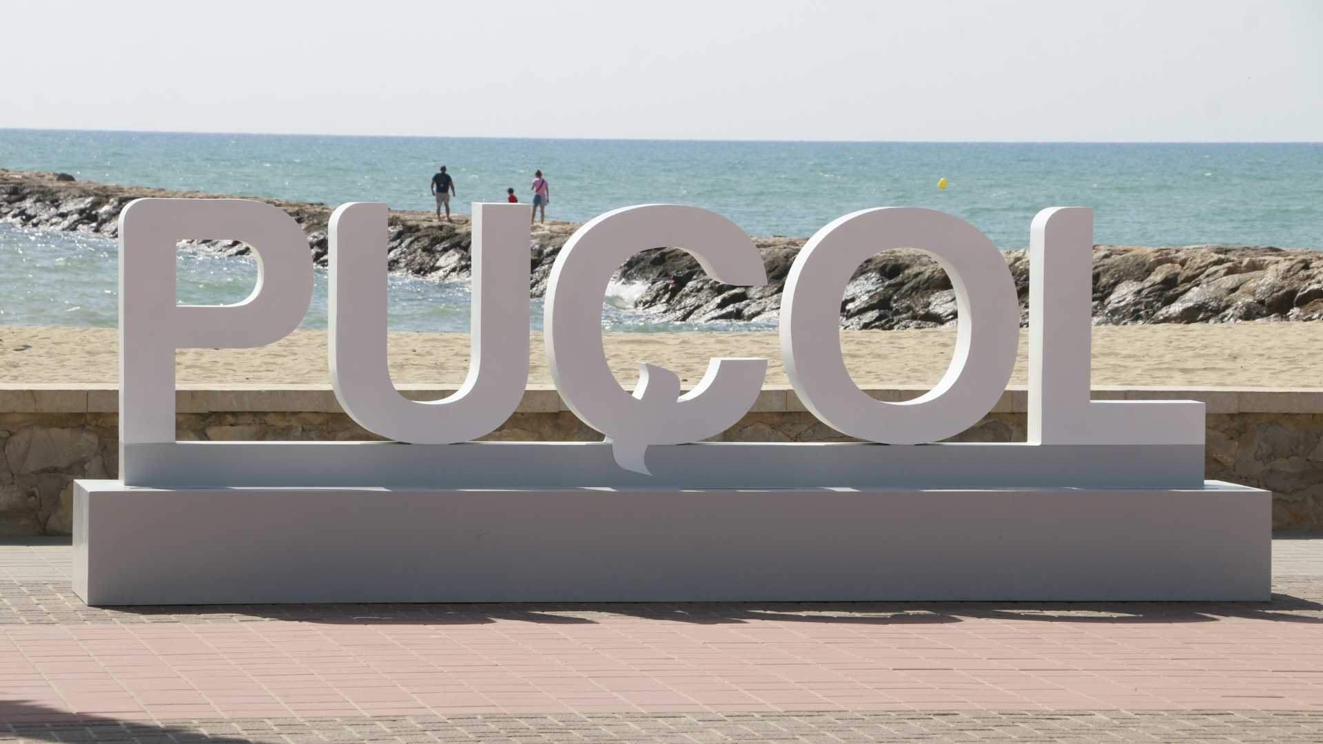 Cartel de Puçol frente al paseo marítimo y la playa